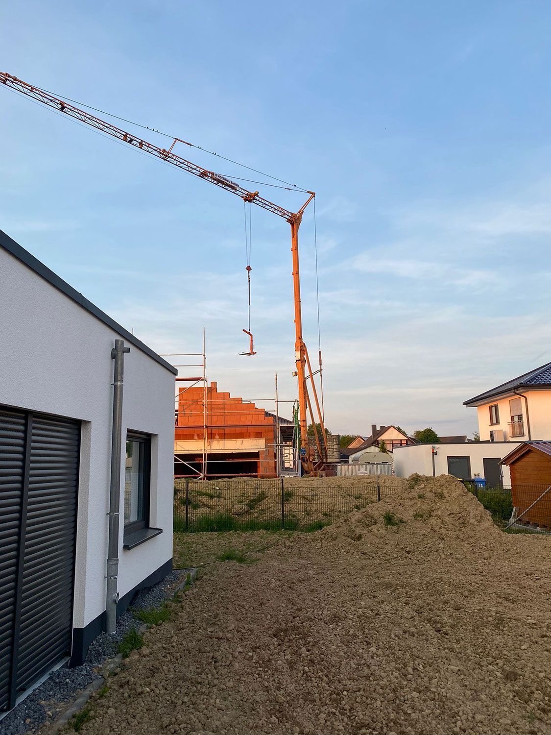 Ein im Bau befindliches Gebäude mit einem Kran im Hintergrund.