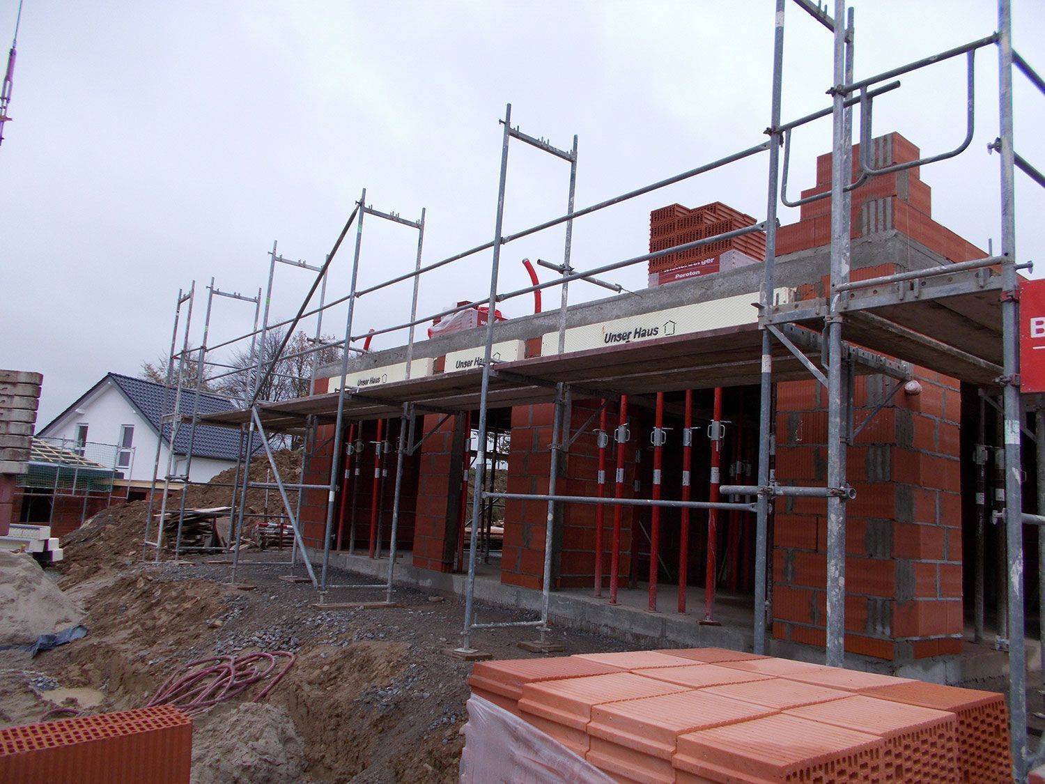 Ein im Bau befindliches Gebäude mit Gerüsten und Ziegeln