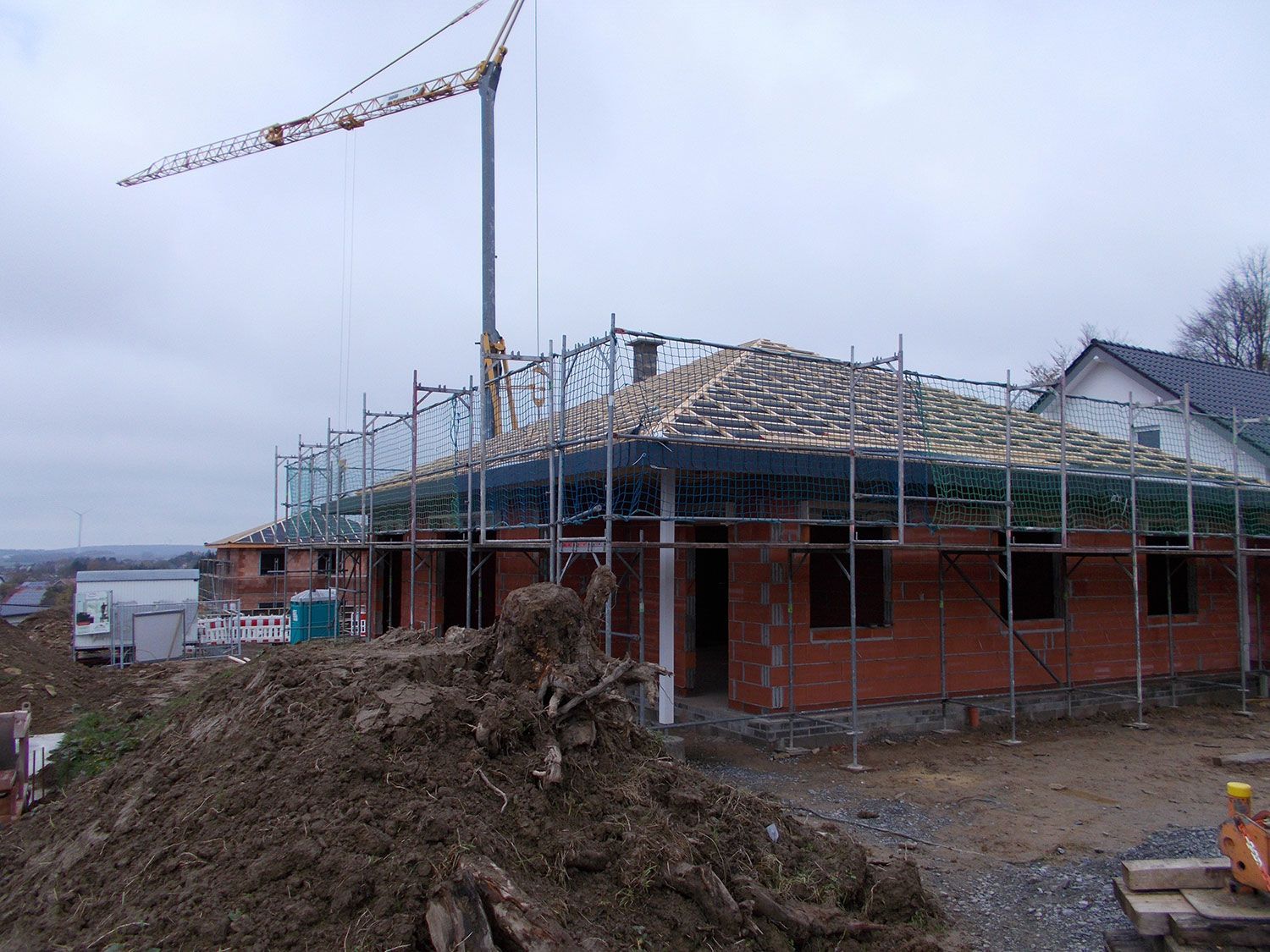 Ein im Bau befindliches Gebäude mit einem Kran im Hintergrund.