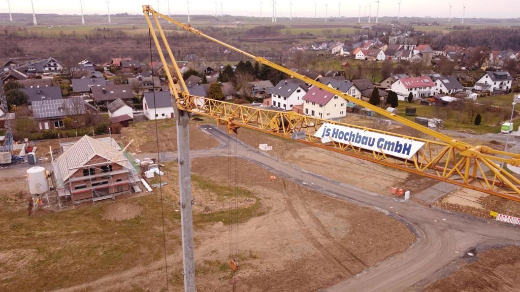 Eine Luftaufnahme einer Baustelle mit einem Kran im Vordergrund.