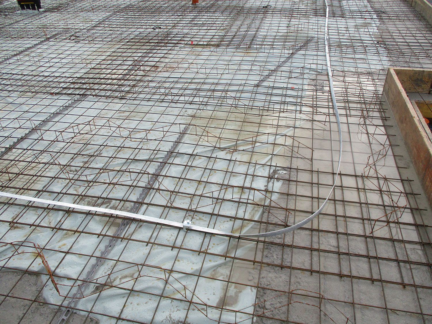 Eine Nahaufnahme eines Betonbodens, der mit einem Drahtgeflecht bedeckt ist.