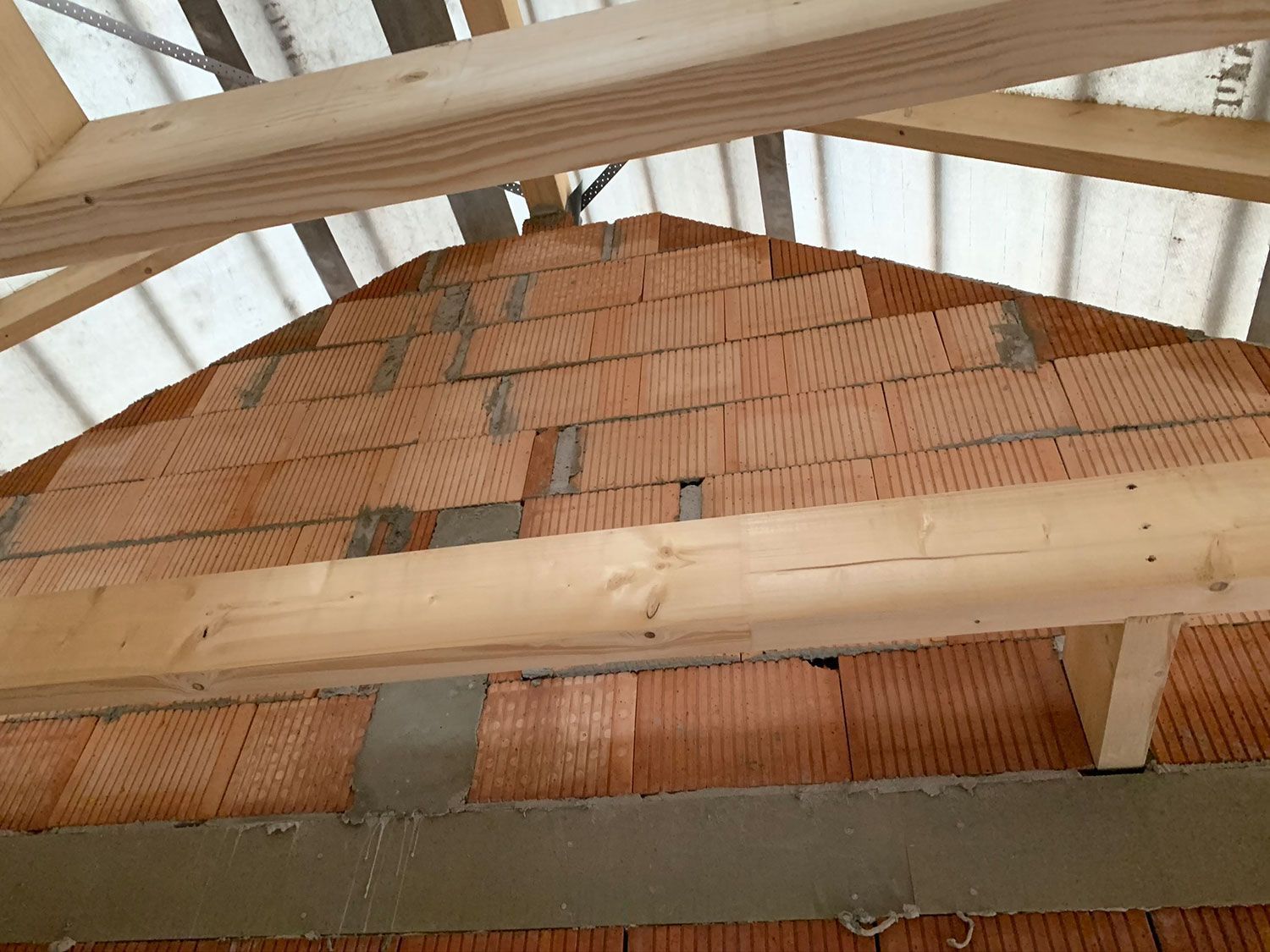 Ein im Bau befindliches Gebäude aus Ziegeln und Holzbalken.