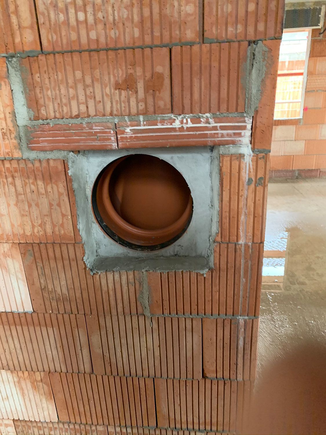 Eine Ziegelmauer mit einem runden Loch in der Mitte.