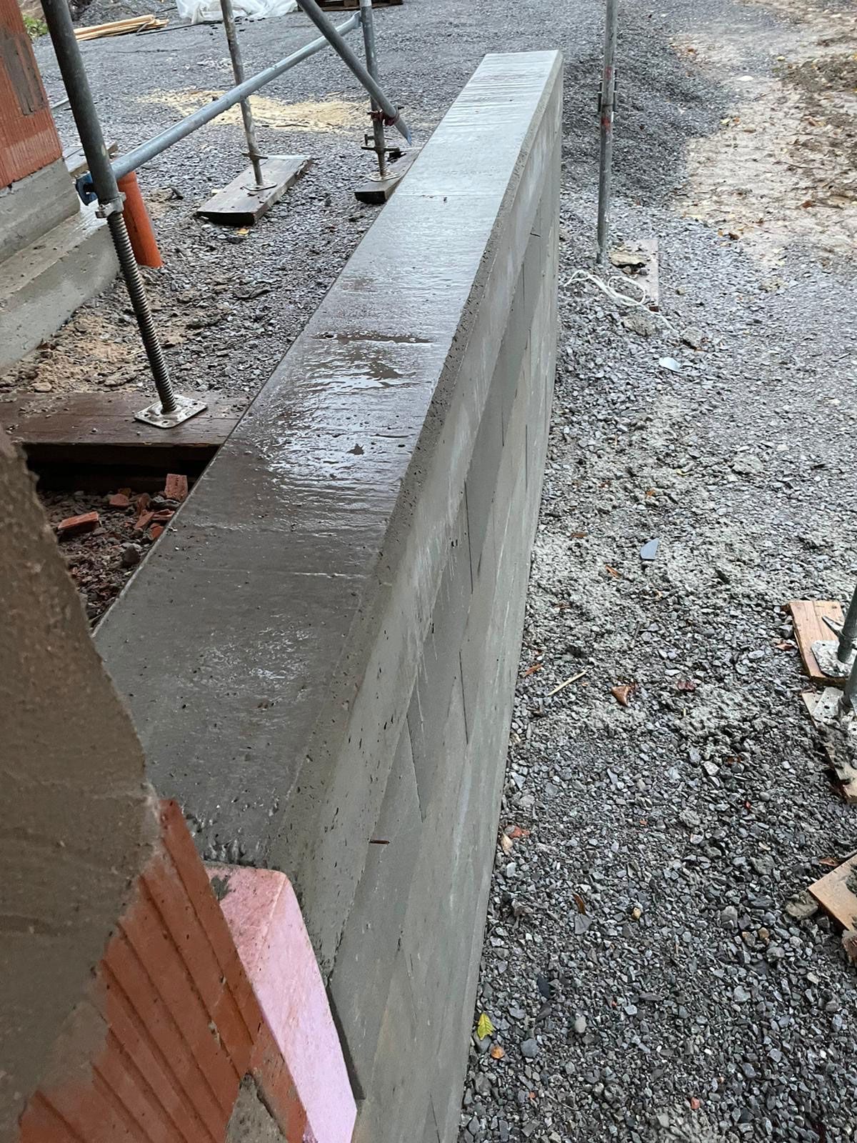 Auf einer Baustelle wird eine Betonmauer gebaut.