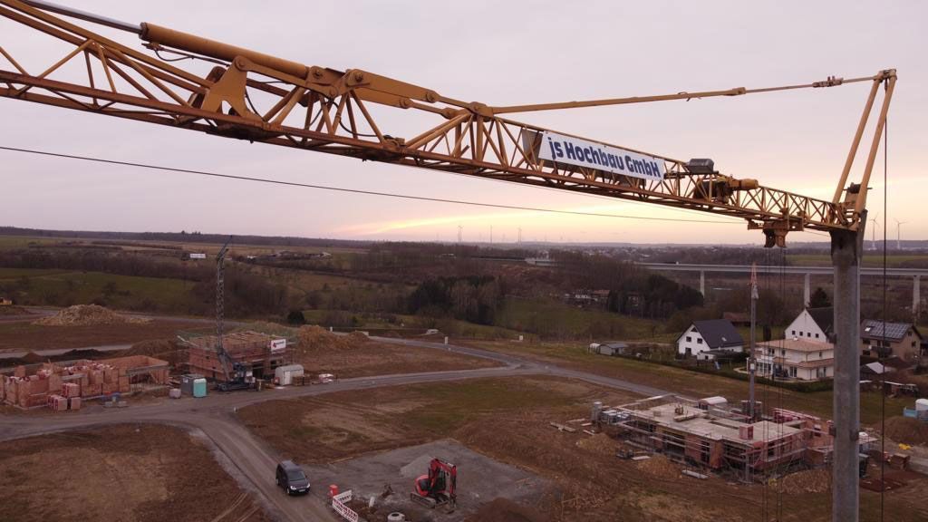 Eine Luftaufnahme einer Baustelle mit einem Kran im Vordergrund.