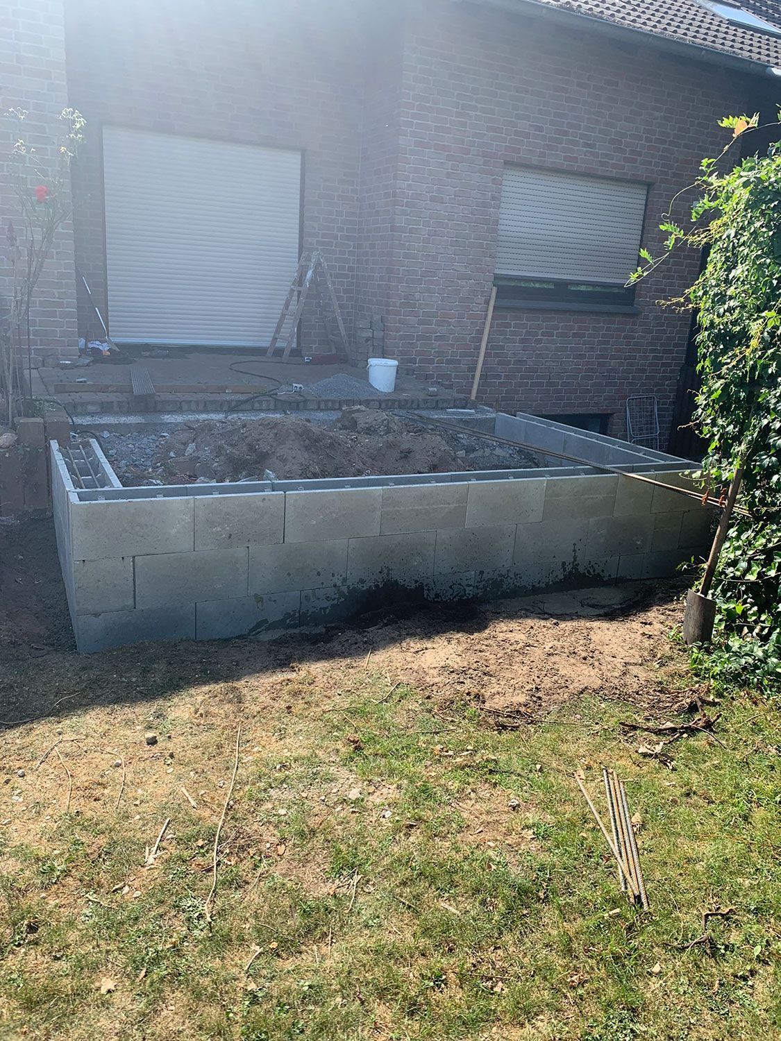 Ein Backsteinhaus mit einem Blumenkasten aus Beton davor.