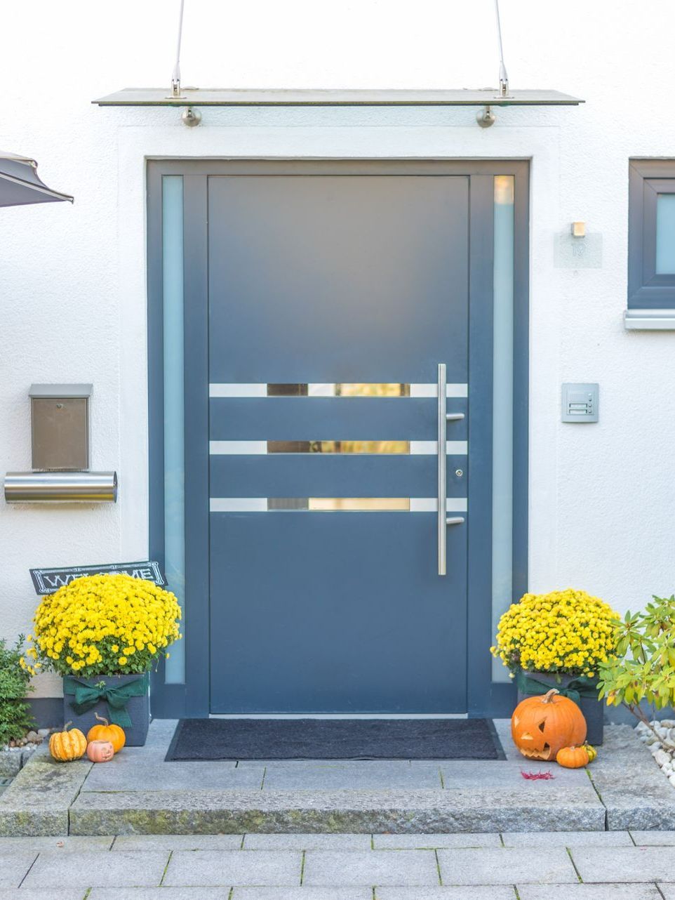 Porte d'entrée grise avec une partie vitrée