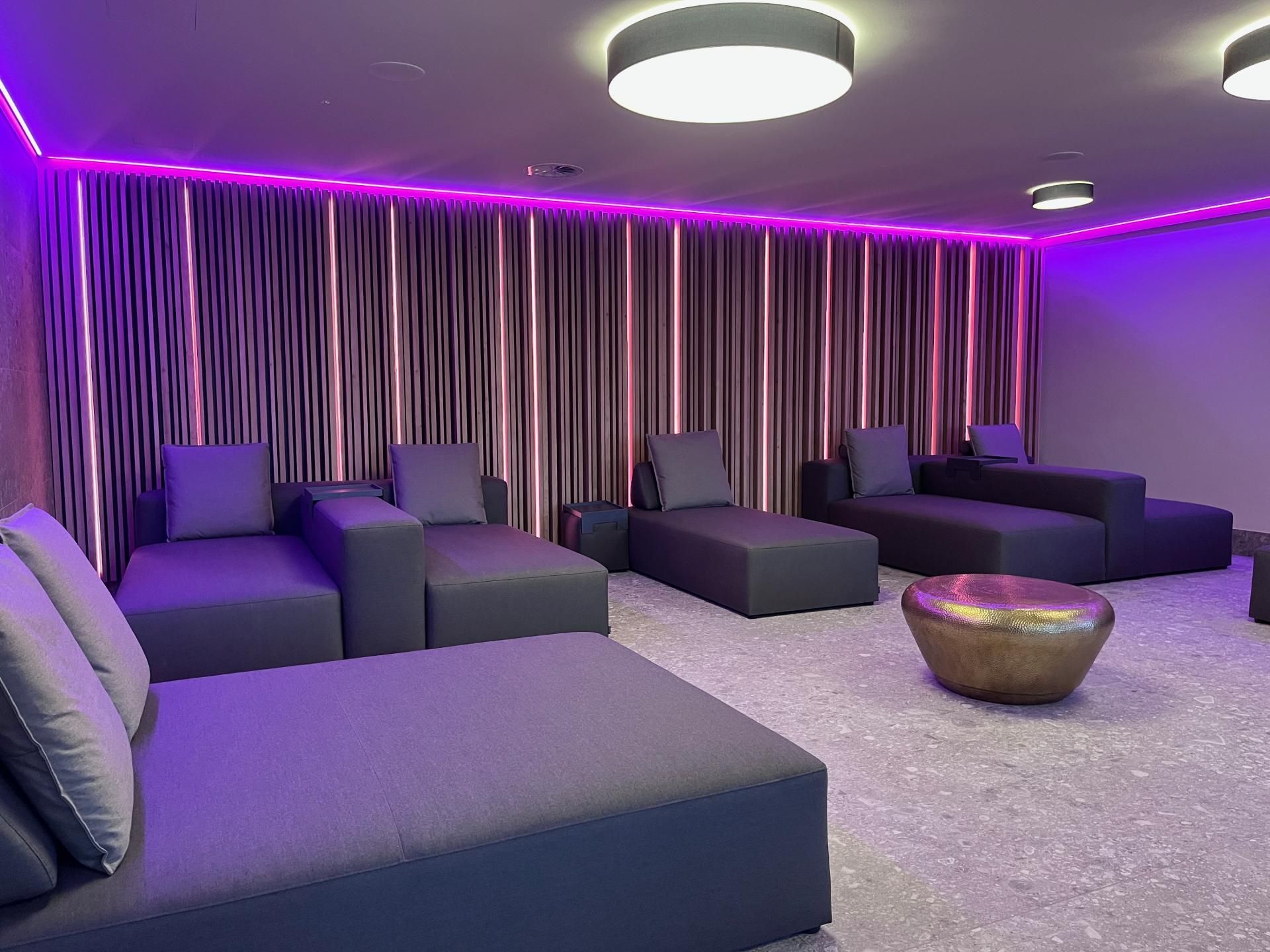Ein großer Ruheraum mit Liegen und violetten Lichtern.