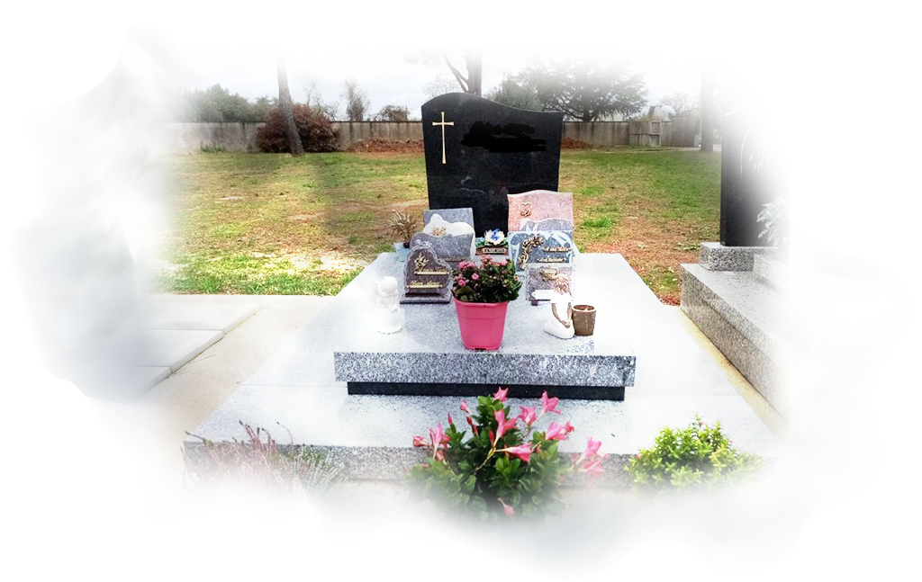 Un monument funéraire avec des plaques et des fleurs dans un cimetière