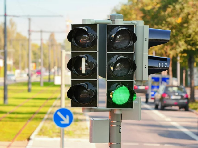 Tien vieressä oleva liikennevalo, jossa vihreä valo palaa.