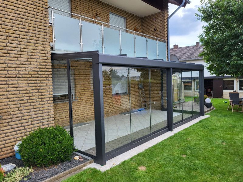 Auf der Seite eines Backsteinhauses befindet sich eine Veranda mit Schiebetüren .