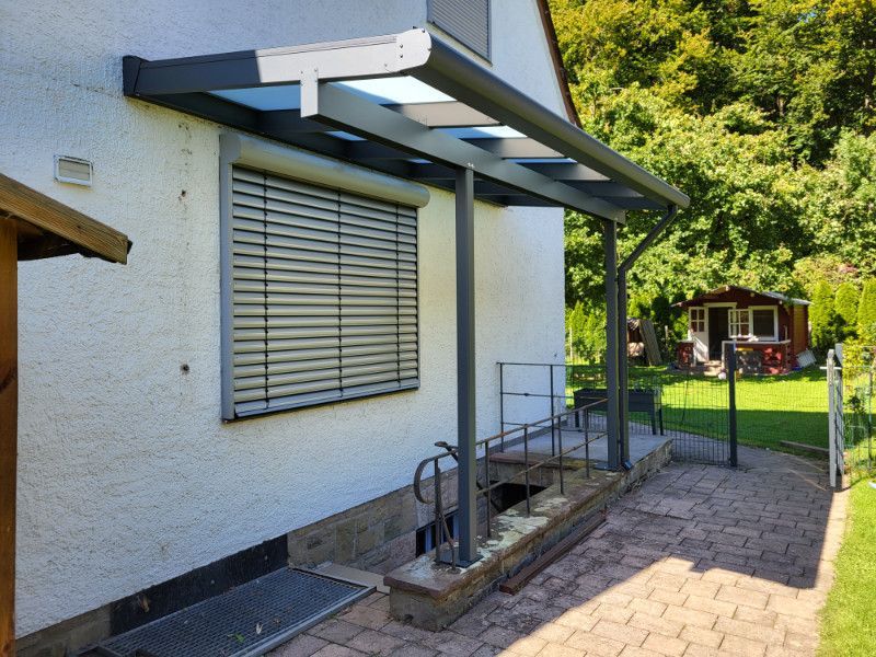 ein weißes Haus mit einer Veranda und einem Fenster .