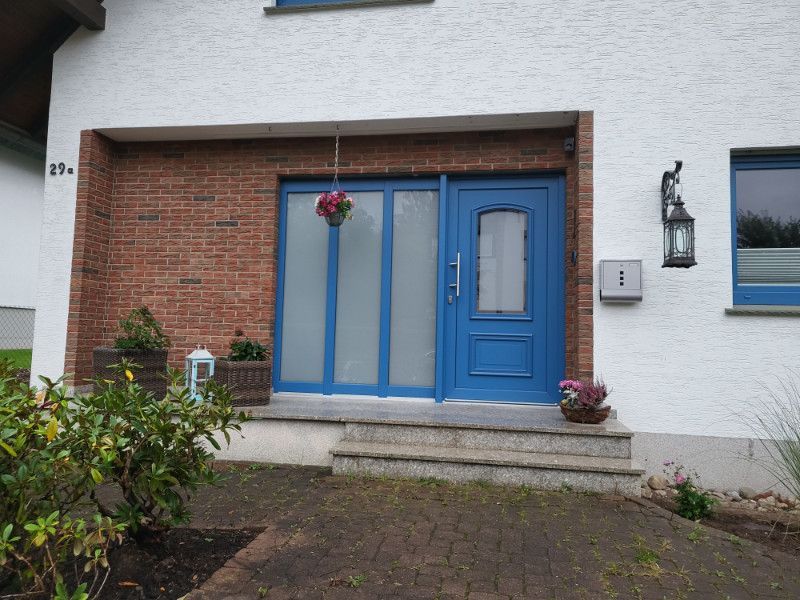 ein weißes Haus mit einer blauen Haustür