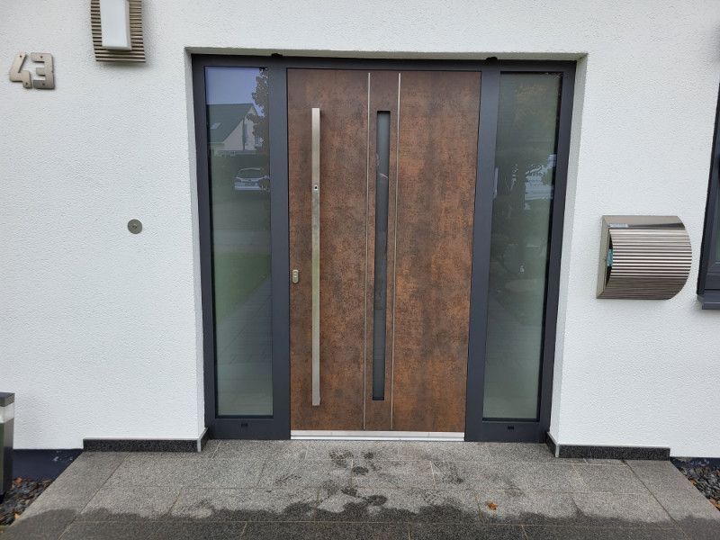 eine braune Haustür mit Glastüren und einem Briefkasten