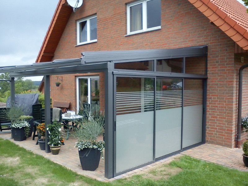 ein Backsteinhaus mit einer Veranda mit Schiebetüren .