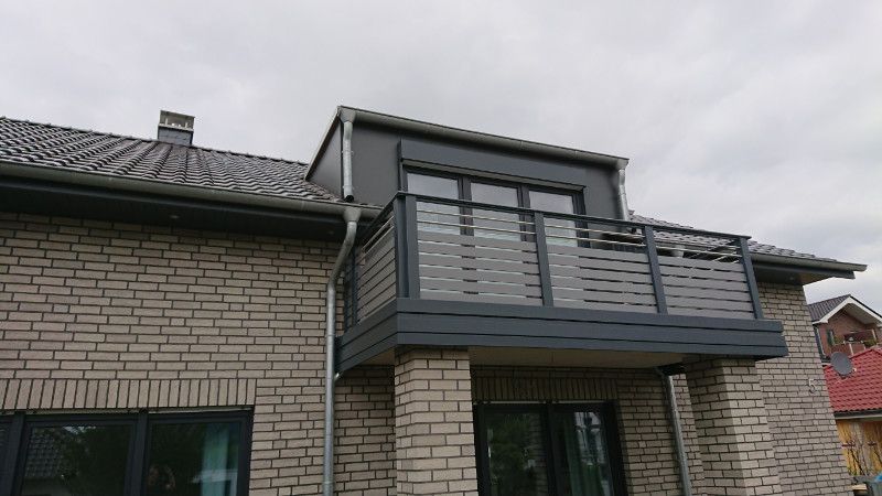 ein Backsteinhaus mit einem Balkon und Fenstern .