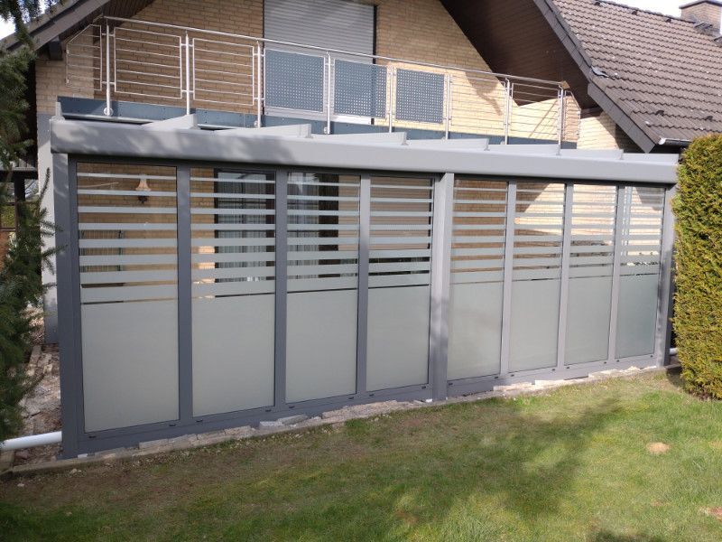 ein Haus mit einer Veranda mit Schiebetüren und einem Balkon