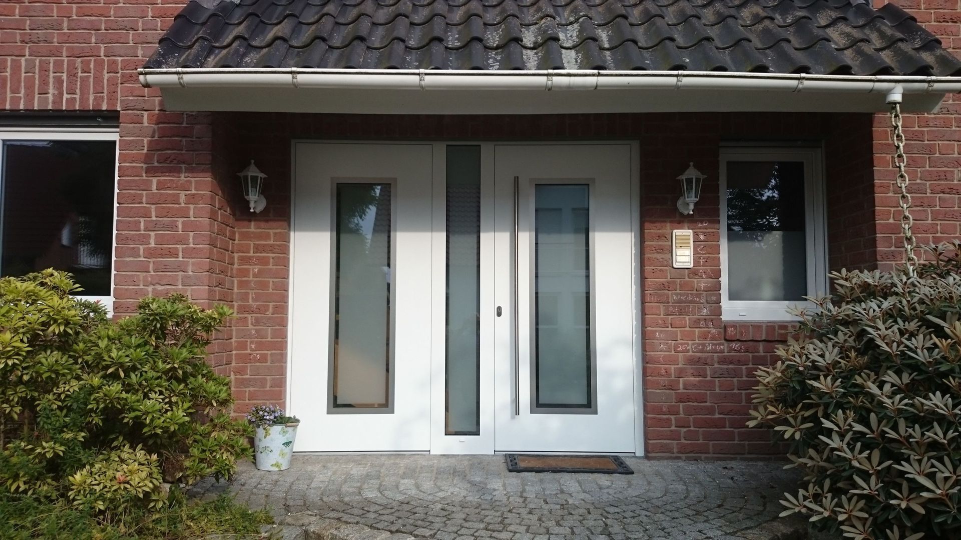 weiße Haustür eines roten Hauses