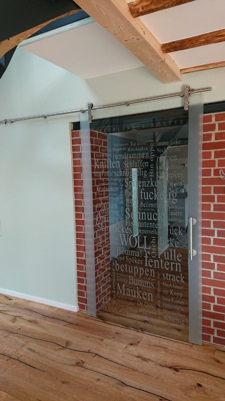 ein Raum mit einer Schiebetür und einer Backsteinmauer .