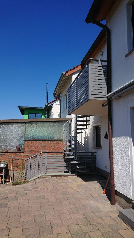 ein weißes Haus mit einem Balkon und einer Treppe .