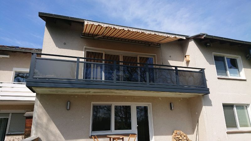 ein Haus mit einem Balkon und vielen Fenstern