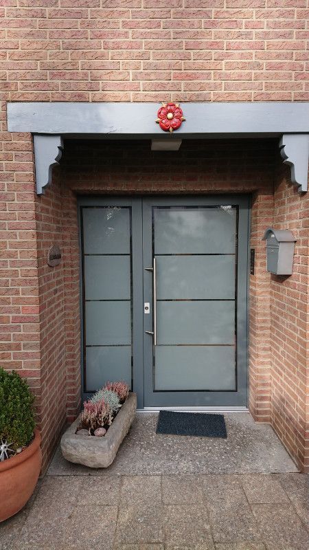 die Eingangstür eines Backsteinhauses mit einer Blume darauf .