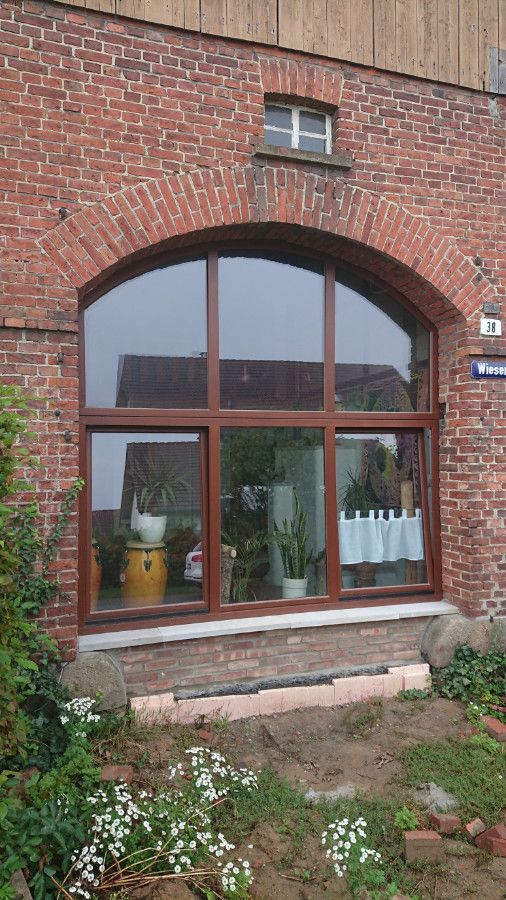 ein großes Fenster an der Seite eines Backsteingebäudes .
