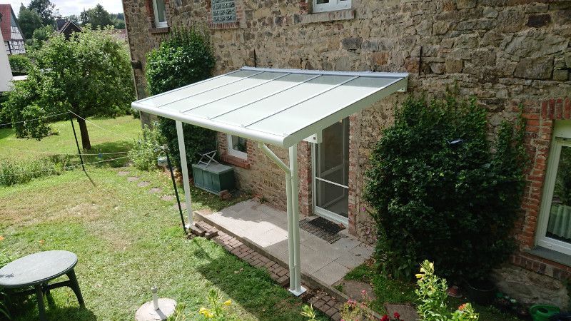 eine weiße Veranda steht vor einem Backsteinhaus .