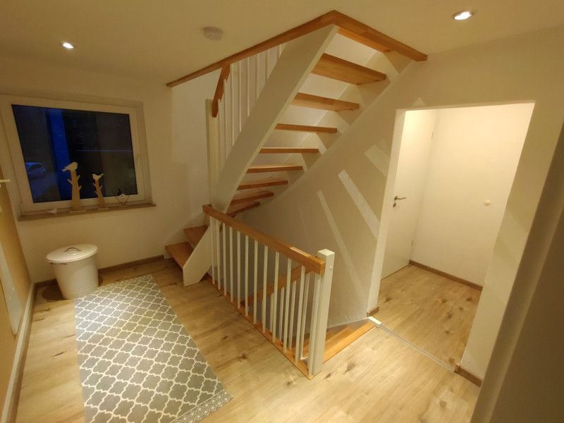 ein Flur mit einer Treppe und einem Fenster