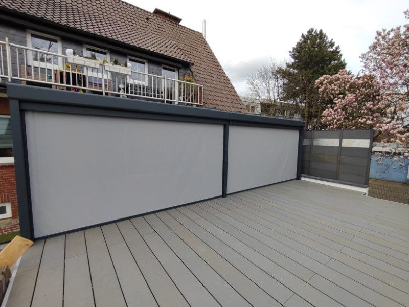 ein Haus mit einem Deck und einem Zaun davor .