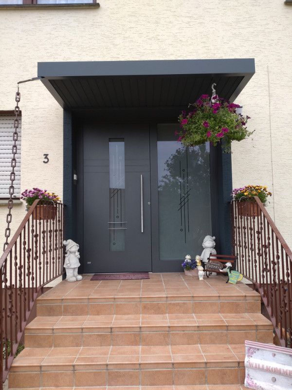 ein Haus mit einer schwarzen Eingangstür und Treppen .