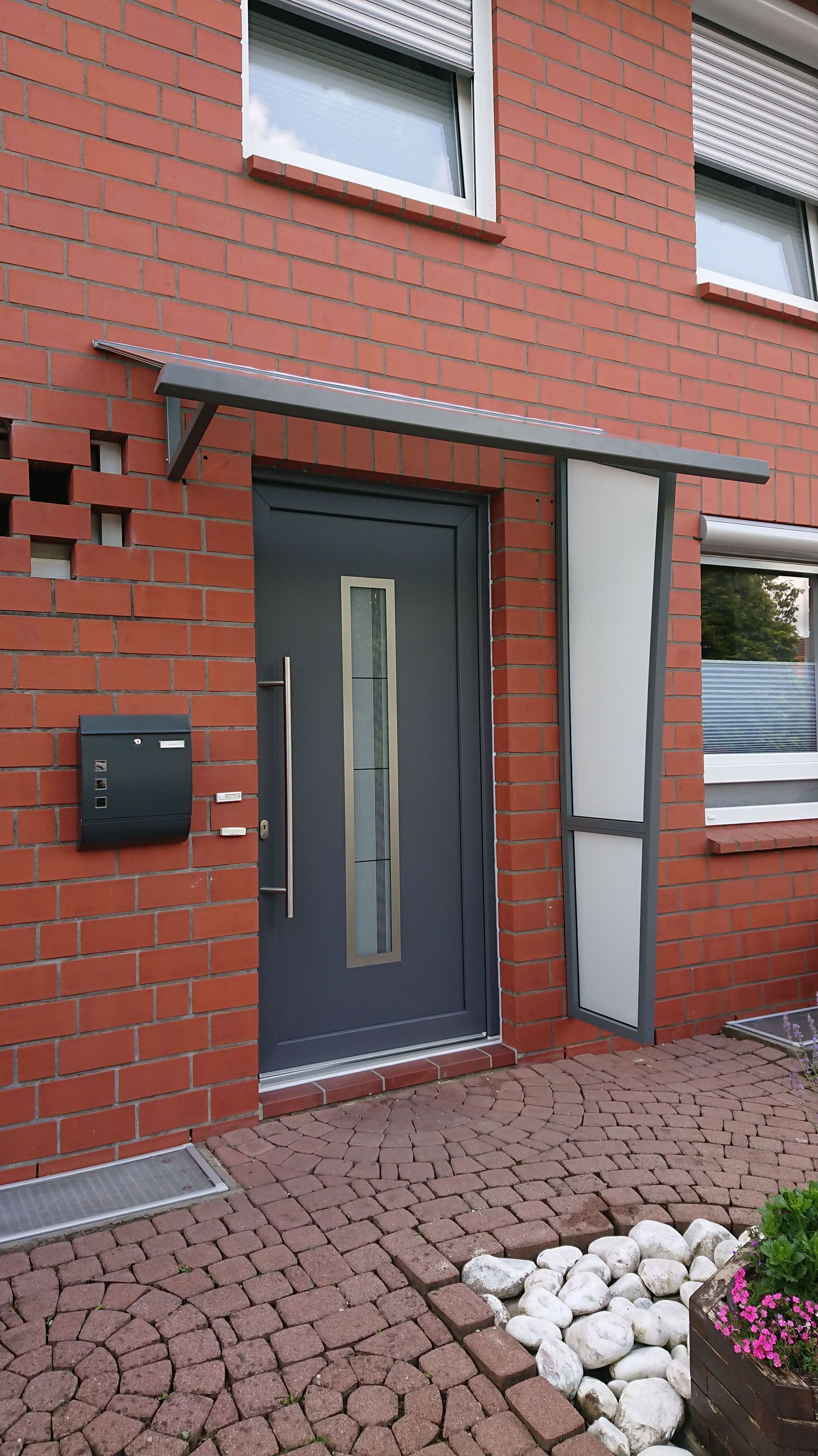 graue Tür eines roten Hauses