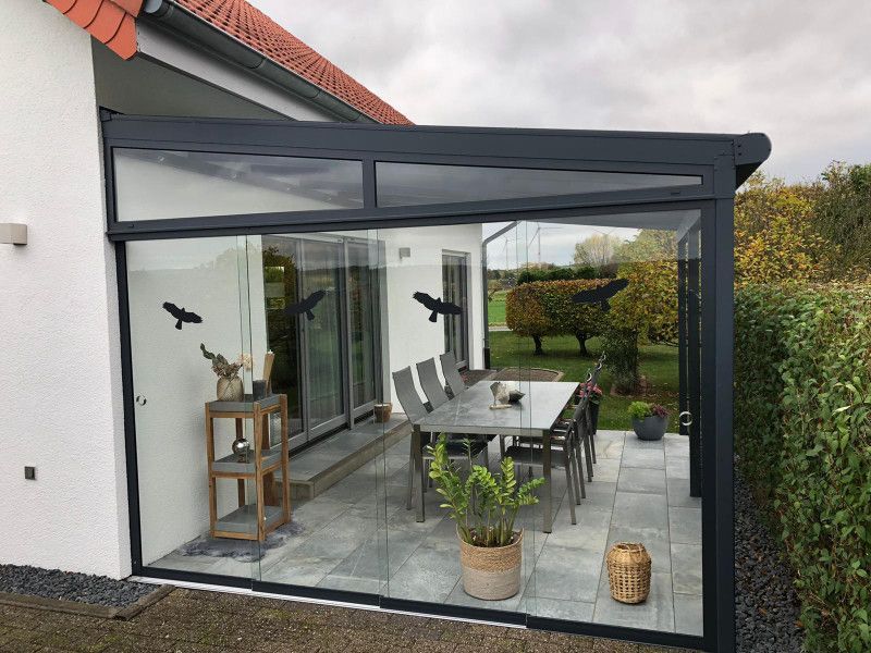 ein weißes Haus mit einem Tisch und Stühlen darauf .