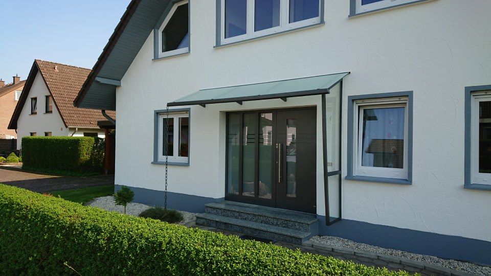 breite Eingangstür eines weißen Hauses