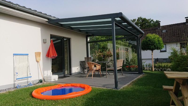 ein Haus mit einer Veranda und einem kleinen Pool im Garten .
