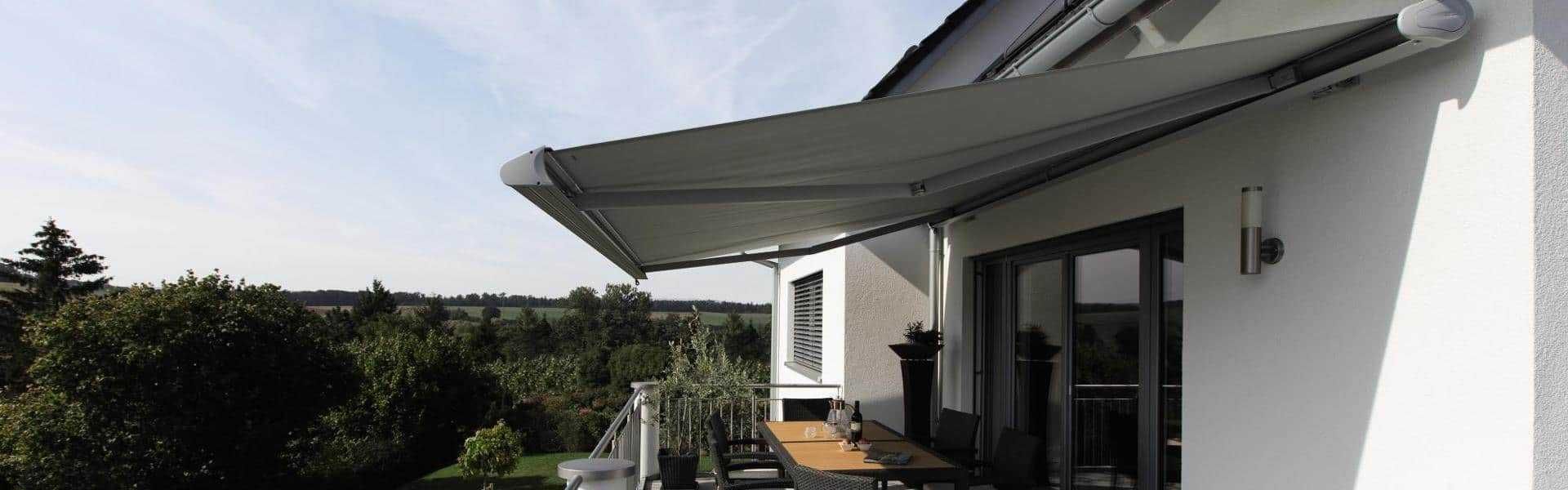 Markise über Balkon mit Tisch und Stühlen