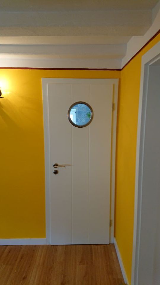 weiße Tür vor gelber Wand