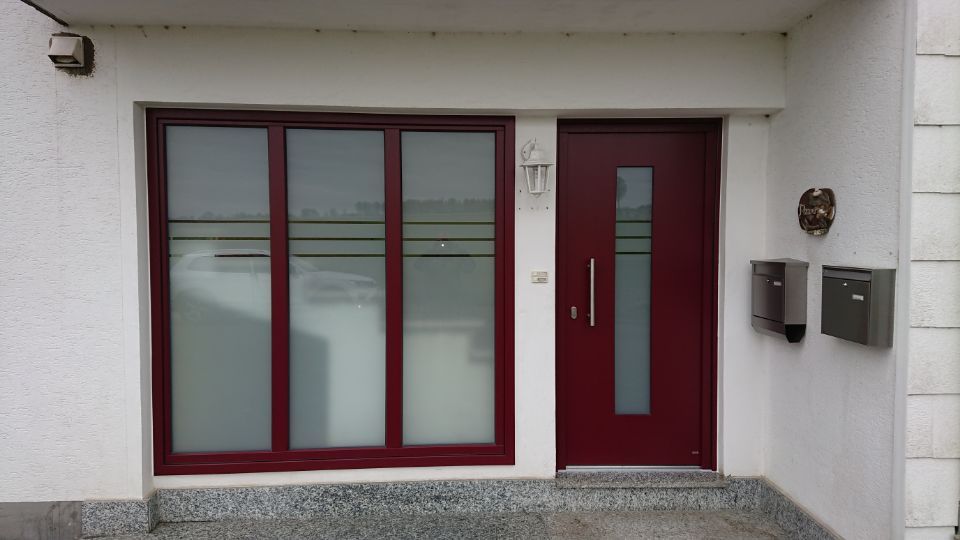 dunkelrote Tür und großes Fenster