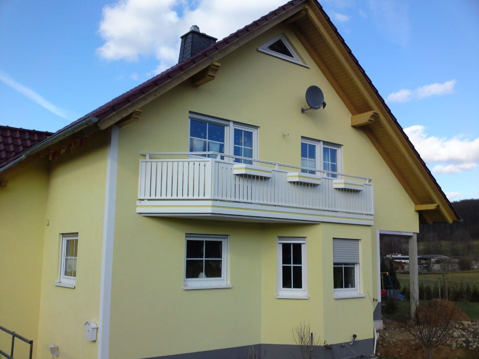 gelbes Haus mit weißem Balkon