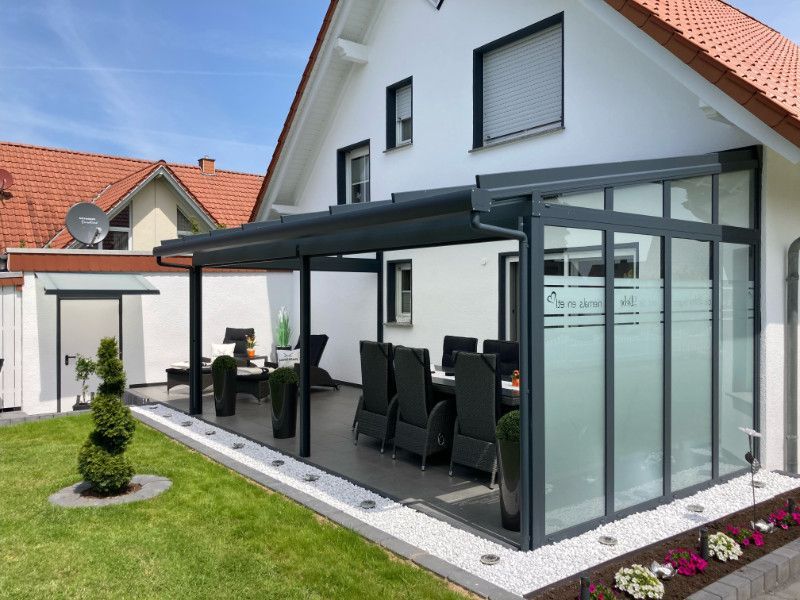ein Haus mit einer Veranda und einem Tisch und Stühlen darauf .