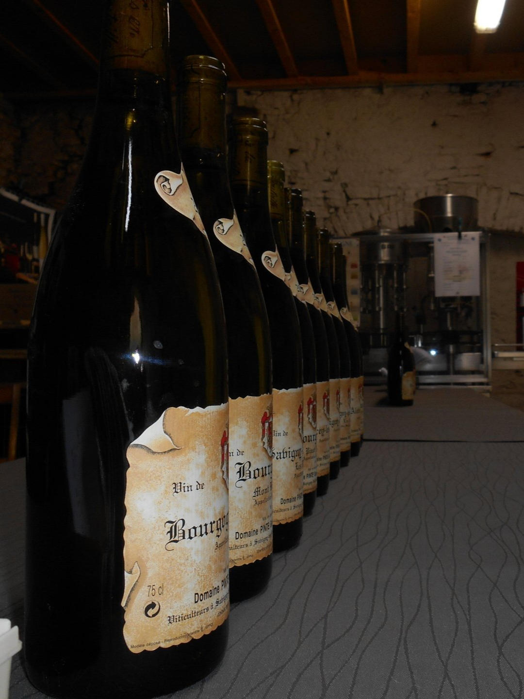 Boîte en carton contenant plusieurs bouteilles de vin rouge, certaines à l'extérieur.