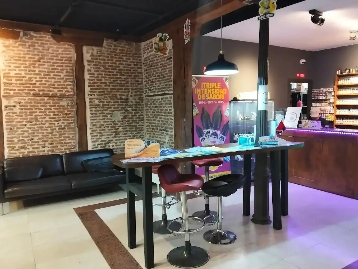 Interior de una tienda con paredes de ladrillo a la vista.