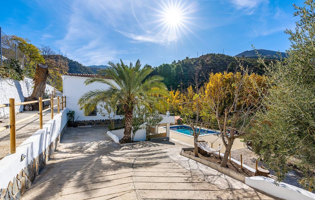 Una piscina con vistas a los árboles y las montañas al fondo.
