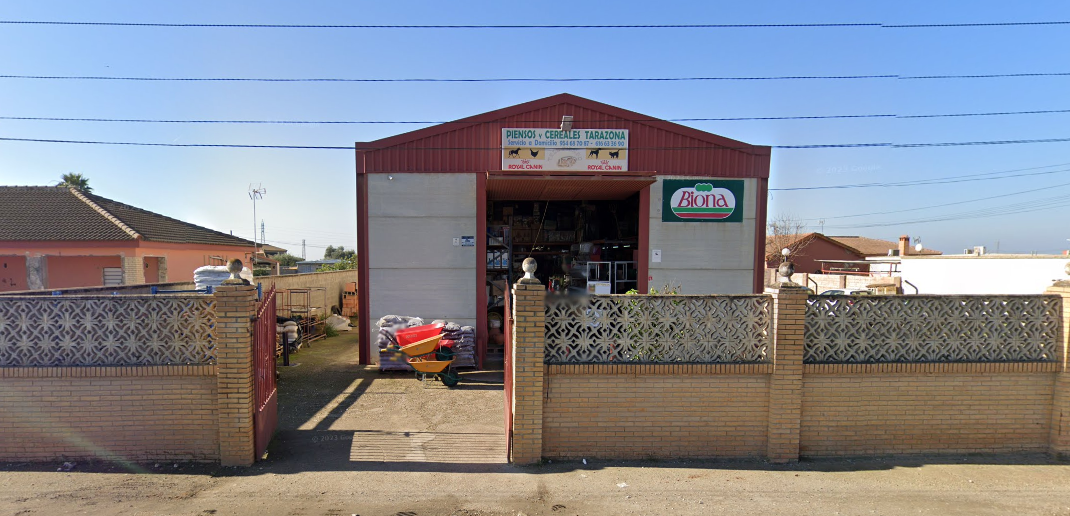 Un edificio rojo y blanco con una valla a su alrededor.