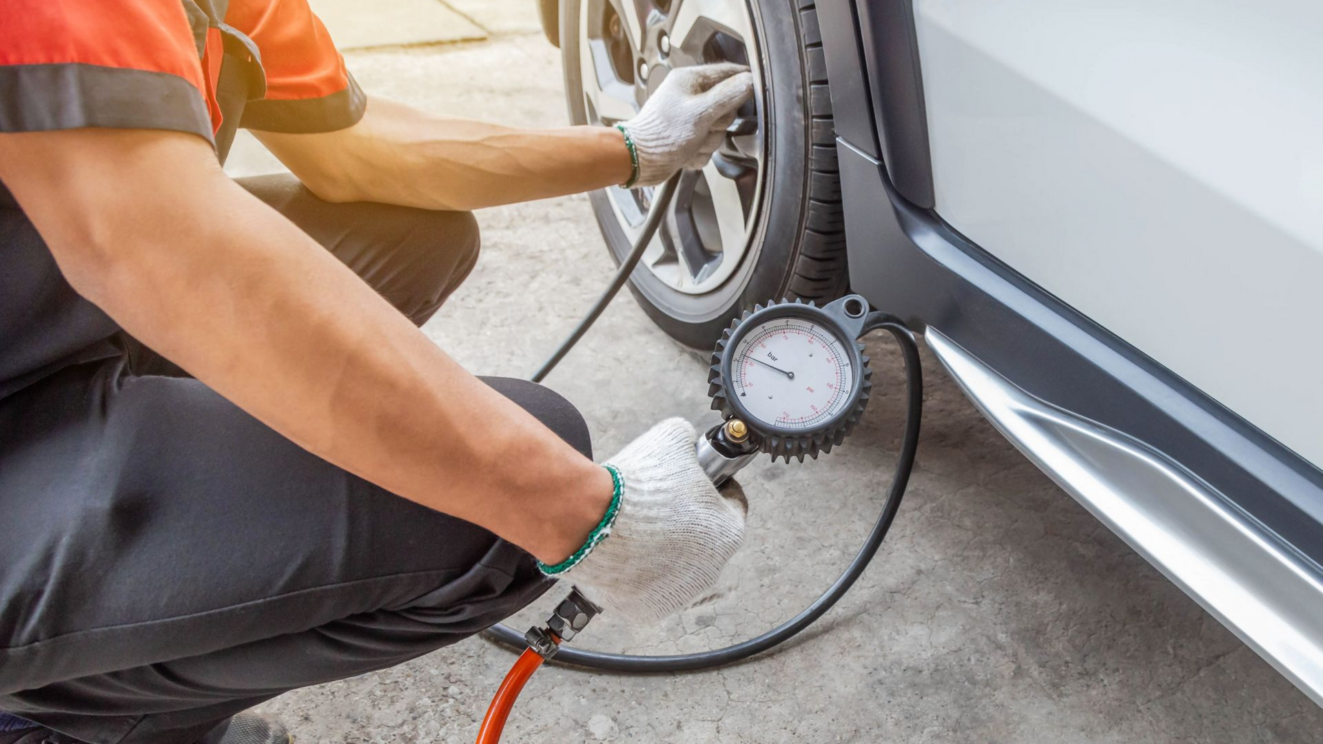 Mécanicien contrôlant la pression d'un pneu