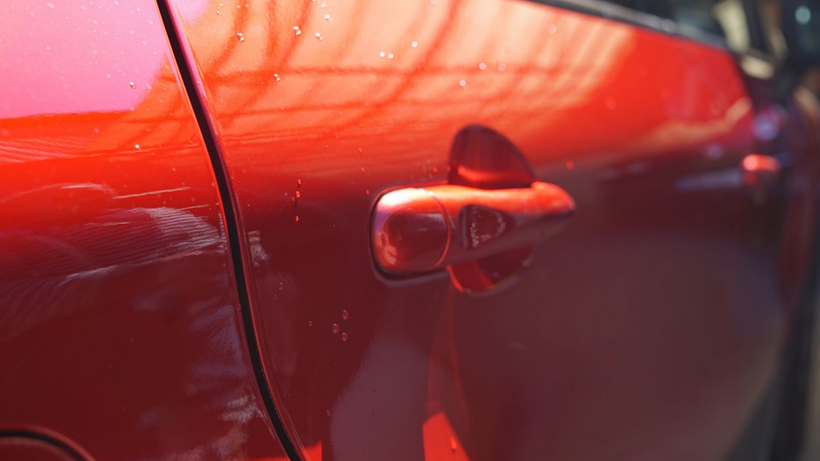 Gros plan sur les rayures d'une carrosserie rouge