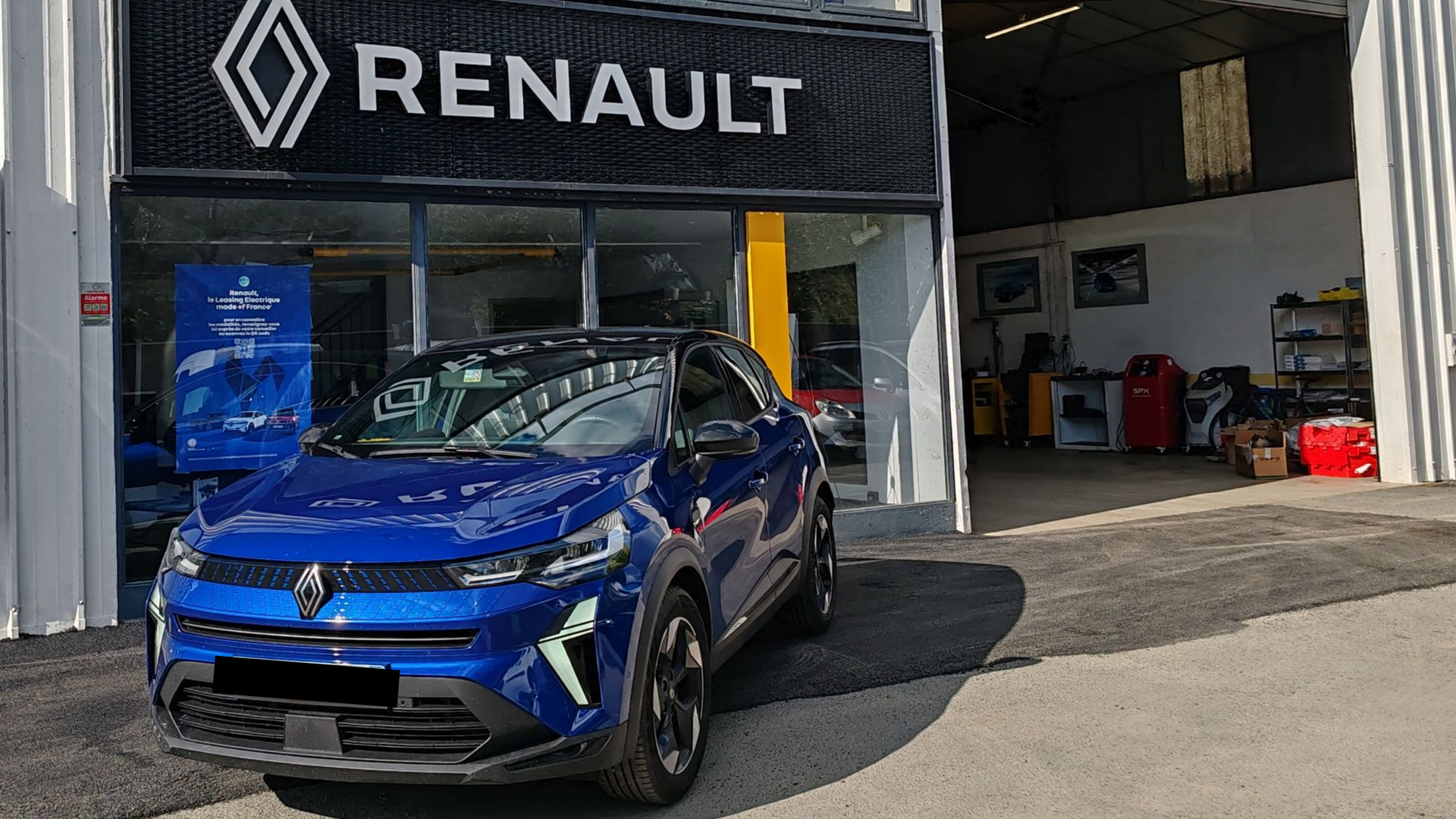 Atelier automobile et voiture bleue garée devant