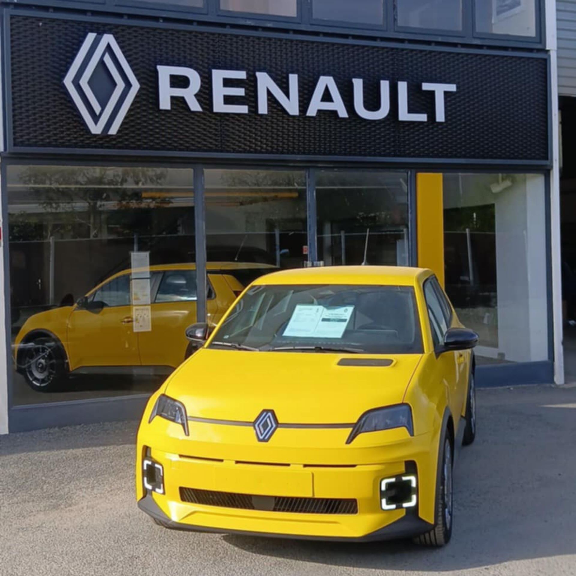 Renault électrique jaune garée devant un garage