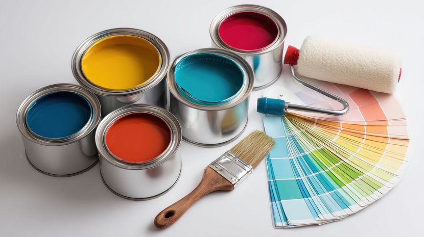 Plusieurs pots de peinture, le nuancier et un pinceau.