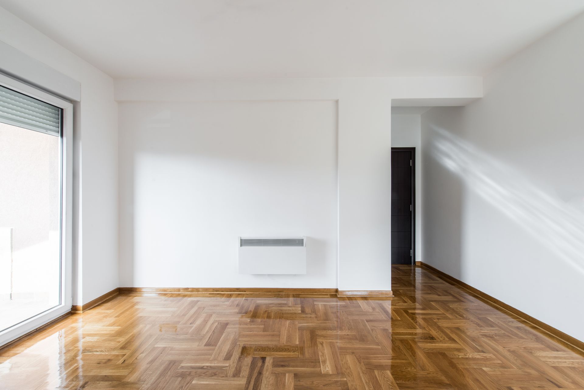 Mur blanc d'un salon avec le parquet au sol.